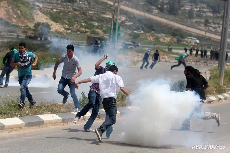 Tear gas fired by Israeli troops falls near Palestinian stone-throwers during clashes next to the Israeli military prison of Ofer, near Beitunia, West Bank, 02 May 2012. The protesters were protesting in solidarity with...