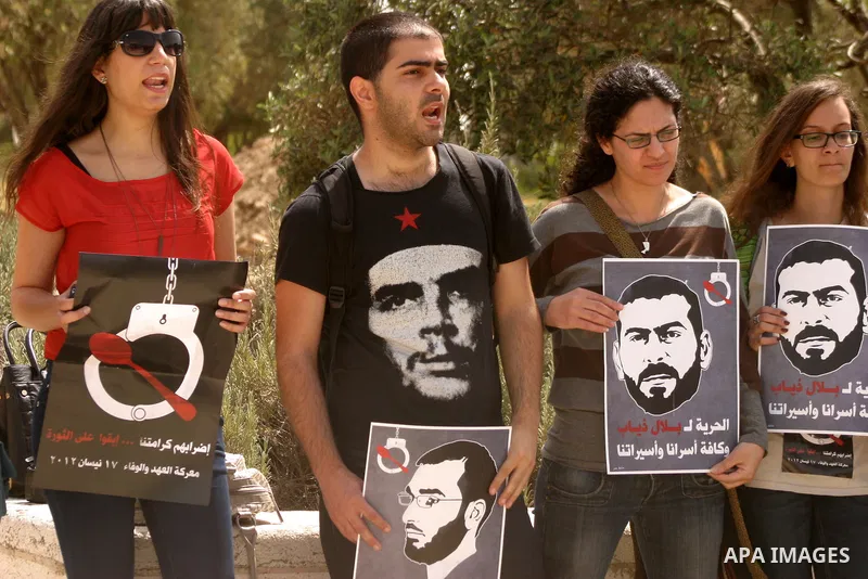 Palestinians and Israeli Arab protesters hold posters depicting Palestinian hunger strikers Thaer Halahla and Bilal Thiab (R) who are in administrative detention during a protest outside Israel's Supreme Court in Jerusal...