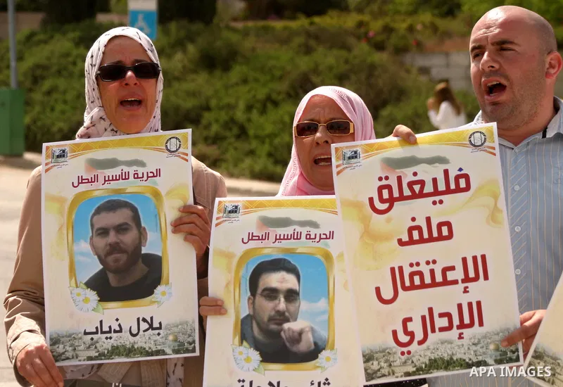 Palestinians and Israeli Arab protesters hold posters depicting Palestinian hunger strikers Thaer Halahla and Bilal Thiab (R) who are in administrative detention during a protest outside Israel's Supreme Court in Jerusal...