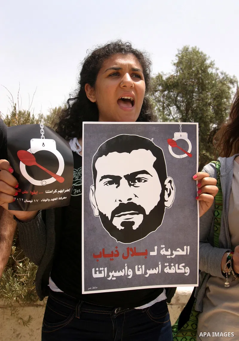Palestinians and Israeli Arab protesters hold posters depicting Palestinian hunger strikers Thaer Halahla and Bilal Thiab (R) who are in administrative detention during a protest outside Israel's Supreme Court in Jerusal...