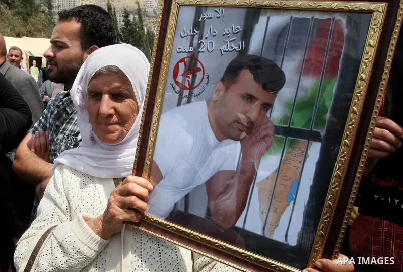 Palestinian woman holds a picture of prisoners jailed in Israel during a rally in solidarity with Palestinian prisoners in Israeli jails, in the West Bank city of Nablus, 03 May, 2012. Over 1,350 Palestinian prisoners ha...