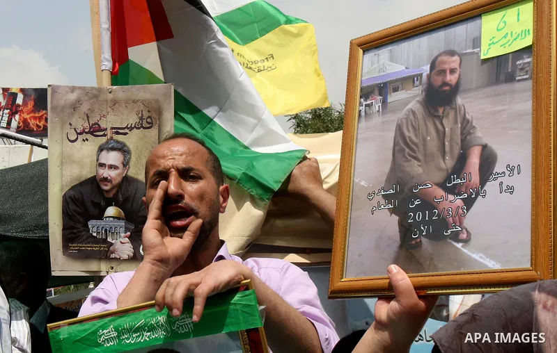 Palestinian protesters hold up pictures and portraits of a prisoners jailed in Israel, during a rally in solidarity with prisoners in Israeli jails, in the West Bank city of Nablus, 03 May, 2012. Over 1,350 Palestinian p...