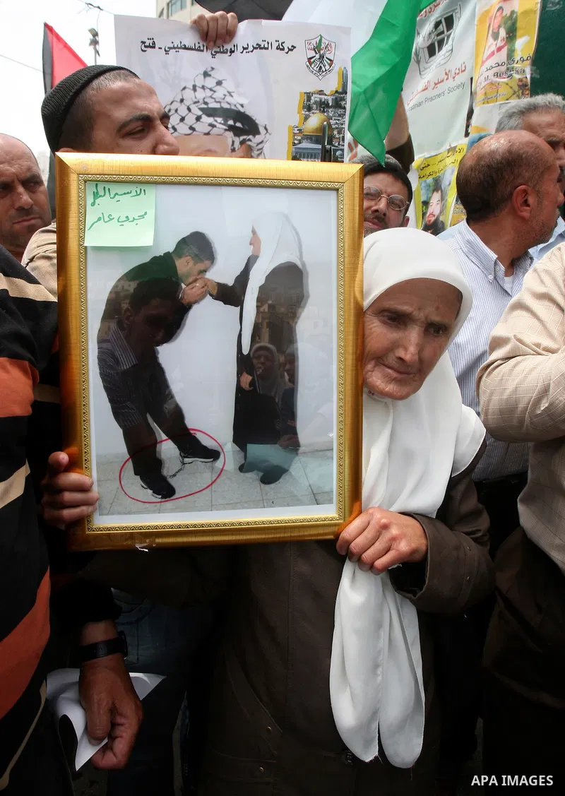 Palestinian woman holds a picture of prisoners jailed in Israel during a rally in solidarity with Palestinian prisoners in Israeli jails, in the West Bank city of Nablus, 03 May, 2012. Over 1,350 Palestinian prisoners ha...