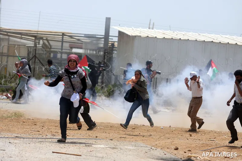 Tear gas fired by Israeli troops falls near Palestinian stone-throwers during clashes next to the Israeli military prison of Ofer, near Beitunia, West Bank, 03 May 2012. following a demonstration in solidarity with Pales...