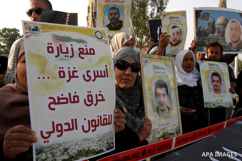 Palestinian protesters hold up banners and portraits of a prisoners jailed in Israel, during a rally next to Al-Ramle Prison, near Tel Aviv, Thursday, May 3, 2012. A Palestinian rights group said recently that half of ab...
