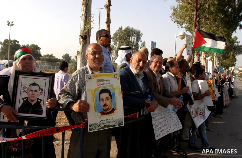 Palestinian protesters hold up banners and portraits of a prisoners jailed in Israel, during a rally next to Al-Ramle Prison, near Tel Aviv, Thursday, May 3, 2012. A Palestinian rights group said recently that half of ab...