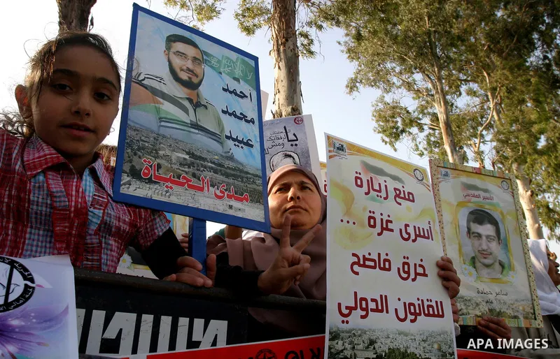 Palestinian protesters hold up banners and portraits of a prisoners jailed in Israel, during a rally next to Al-Ramle Prison, near Tel Aviv, Thursday, May 3, 2012. A Palestinian rights group said recently that half of ab...