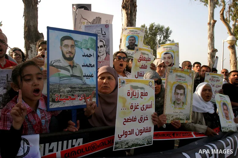Palestinian protesters hold up banners and portraits of a prisoners jailed in Israel, during a rally next to Al-Ramle Prison, near Tel Aviv, Thursday, May 3, 2012. A Palestinian rights group said recently that half of ab...