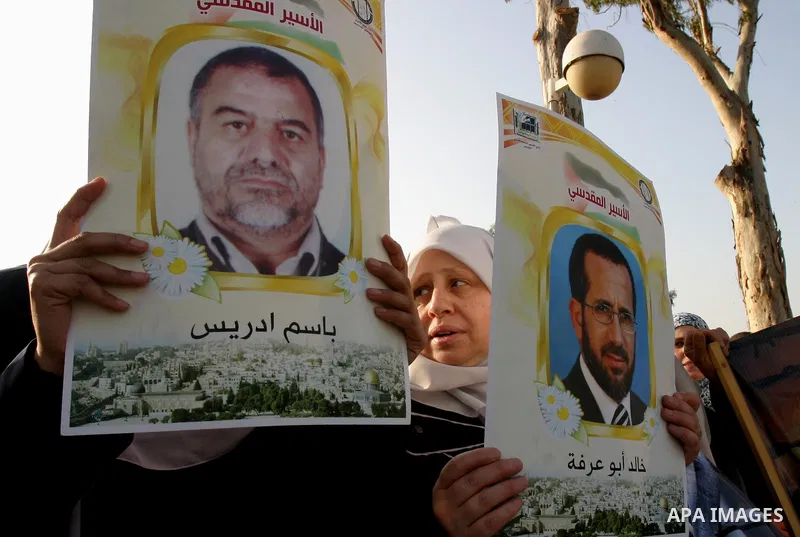 Palestinian protesters hold up banners and portraits of a prisoners jailed in Israel, during a rally next to Al-Ramle Prison, near Tel Aviv, Thursday, May 3, 2012. A Palestinian rights group said recently that half of ab...