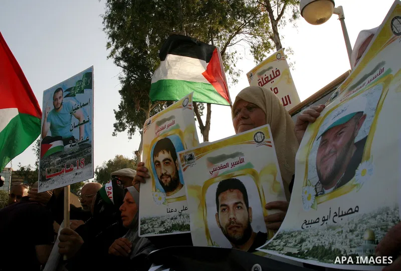 Palestinian protesters hold up banners and portraits of a prisoners jailed in Israel, during a rally next to Al-Ramle Prison, near Tel Aviv, Thursday, May 3, 2012. A Palestinian rights group said recently that half of ab...