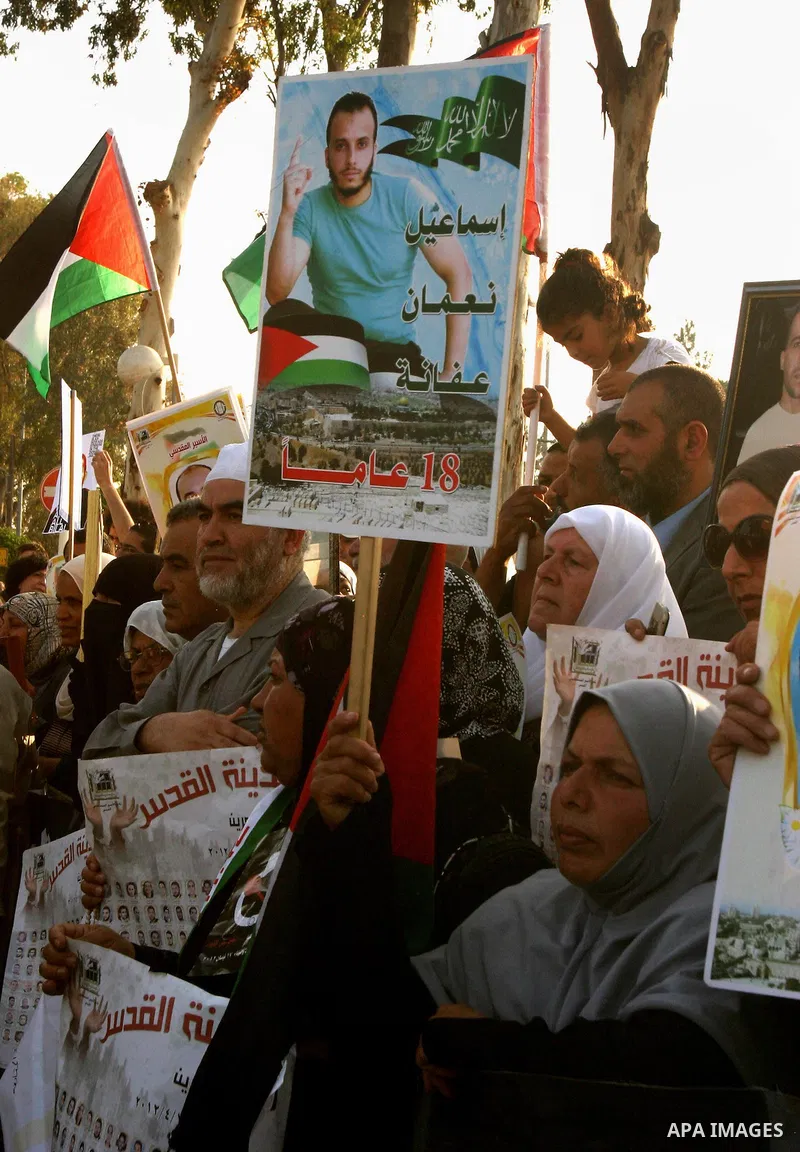 Palestinian protesters hold up banners and portraits of a prisoners jailed in Israel, during a rally next to Al-Ramle Prison, near Tel Aviv, Thursday, May 3, 2012. A Palestinian rights group said recently that half of ab...