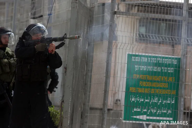 Israeli troops fire tear gas and rubber bullets towards Palestinian stone-throwers during clashes with Palestinian stone-throwers in Qalandia in the occupied West Bank, following a demonstration on May 4, 2012 solidarity...