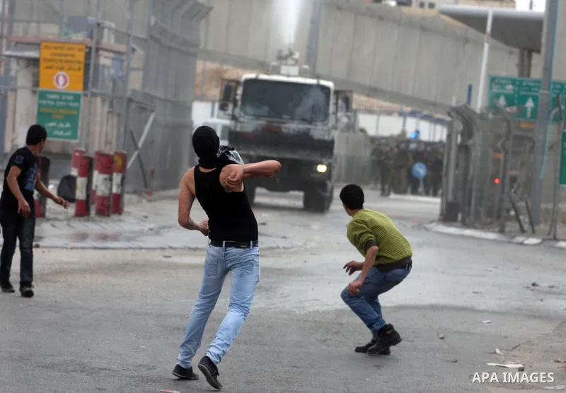 Palestinian men throw stones at Israeli soldiers at the Qalandia crossing in the occupied West Bank during a demonstration on May 4, 2012 in solidarity with Palestinian prisoners on hunger strike to protest Israel's use...