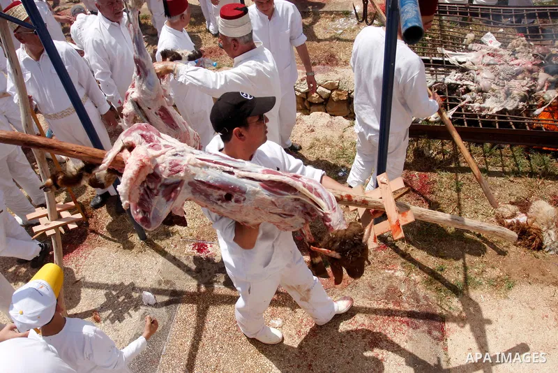 Members of the ancient Samaritan community carry a sheep to the slaughter during the traditional Passover sacrifice in Mount Gerizim, in the northern West Bank city of Nablus, 04 May 2012. According to tradition, the Sam...
