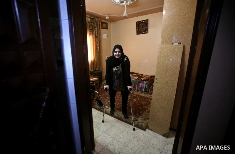 Jamela Al-Habash, a 17-year-old Palestinian girl who lost her legs, uses a pair of crutches to help her to walk with her artificial limbs before leaving her family's home in the Jabaliya refugee camp in the Gaza Strip, 0...