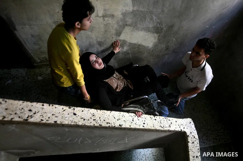 Jamela Al-Habash (C), a 17-year-old Palestinian girl who lost her legs, is helped by her brothers to be carried downstairs before leaving her family's home in the Jabaliya refugee camp in the Gaza Strip, 03 May 2012. Al-...