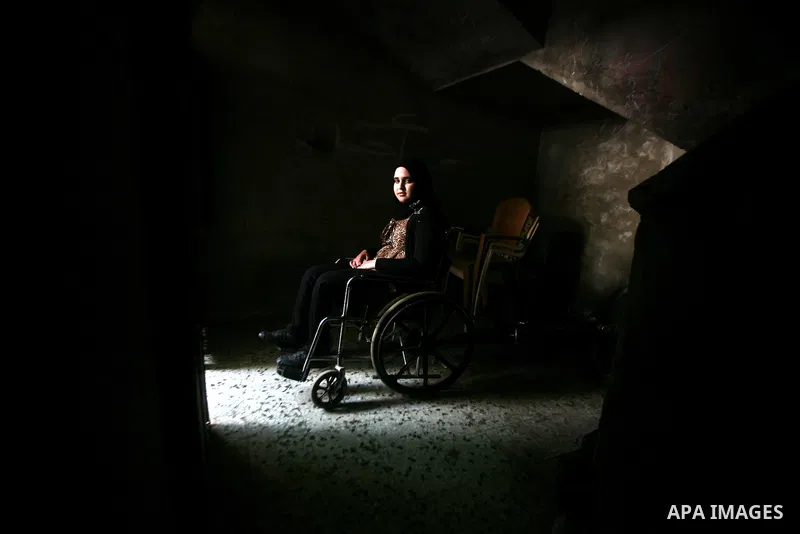 Jamela Al-Habash, a 17-year-old Palestinian girl who lost her legs, sits in a wheelchair waiting for her brothers to help her leaving her family's home in the Jabaliya refugee camp in the Gaza Strip, 03 May 2012. Al-Haba...