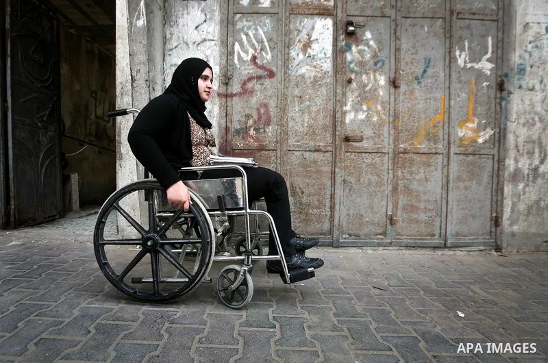 Jamela Al-Habash, a 17-year-old Palestinian girl who lost her legs, sits in a wheelchair waiting for her brothers to help her leaving her family's home in the Jabaliya refugee camp in the Gaza Strip, 03 May 2012. Al-Haba...