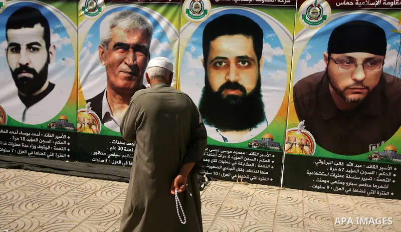 A Palestinian old man walks in front of posters of hunger striking Palestinian inmates of Israeli prisons during a sit-in solidarity protest in a tent, in Gaza City, Gaza Strip, on 04 May 2012. Protests continued in soli...