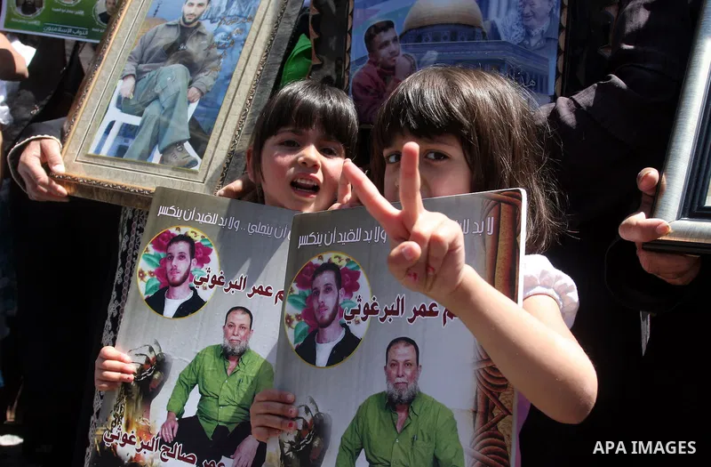 Supporters of the Islamic Hamas movement hold a rally in the West Bank city of Ramallah, calling for the release of prisoners being held in Israeli prisons on May 5, 2012, as ten Palestinian hunger strikers held at an Is...