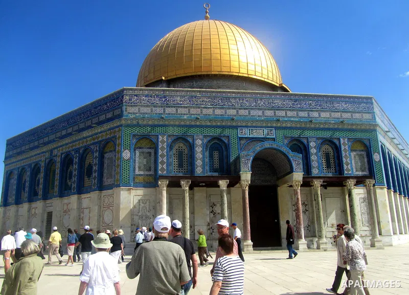 Palestinians and Tourists walk in front of the Dome of the Rock at Al-Aqsa mosque compound in Jerusalem's old city on May 6,2012. Photo by Mahfouz Abu Turk