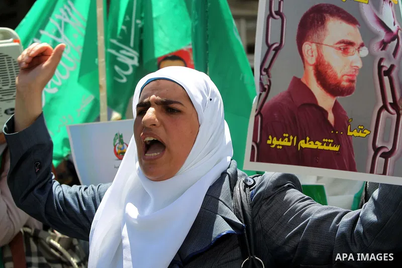Palestinians participate in a rally supporting Palestinian inmates on hunger strike since mid-April 2012, in the West Bank City of Hebron, May 7, 2012. A Palestinian rights group said recently that half of about 5,000 Pa...