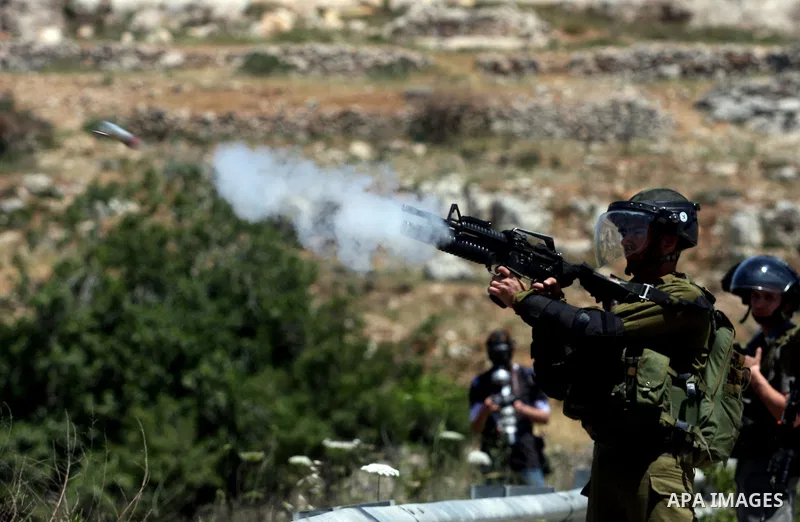An Israeli soldier fires tear gas grenade to Palestinian protesters during a protest outside Ofer prison near the West Bank city of Ramallah, on May 7, 2012. The Palestinian National Authority (PNA) on Monday welcomed th...