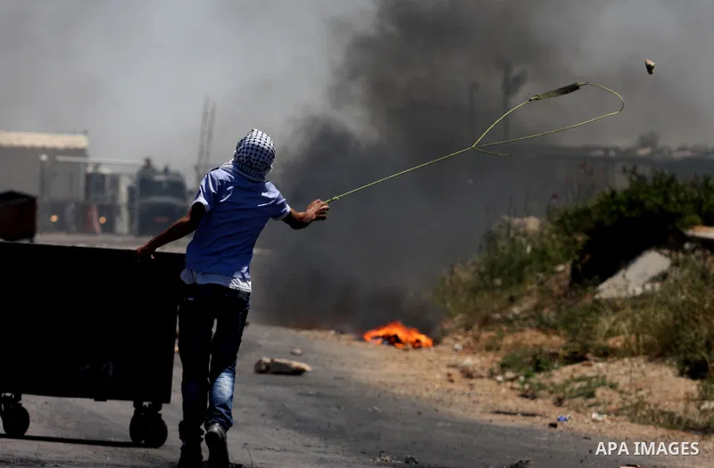 A Palestinian uses a sling to lob a stone during clashes with Israeli soldiers outside the Ofer Prison close to the West Bank city of Ramallah, following a march in support of Palestinian prisoners of on hunger strike wh...