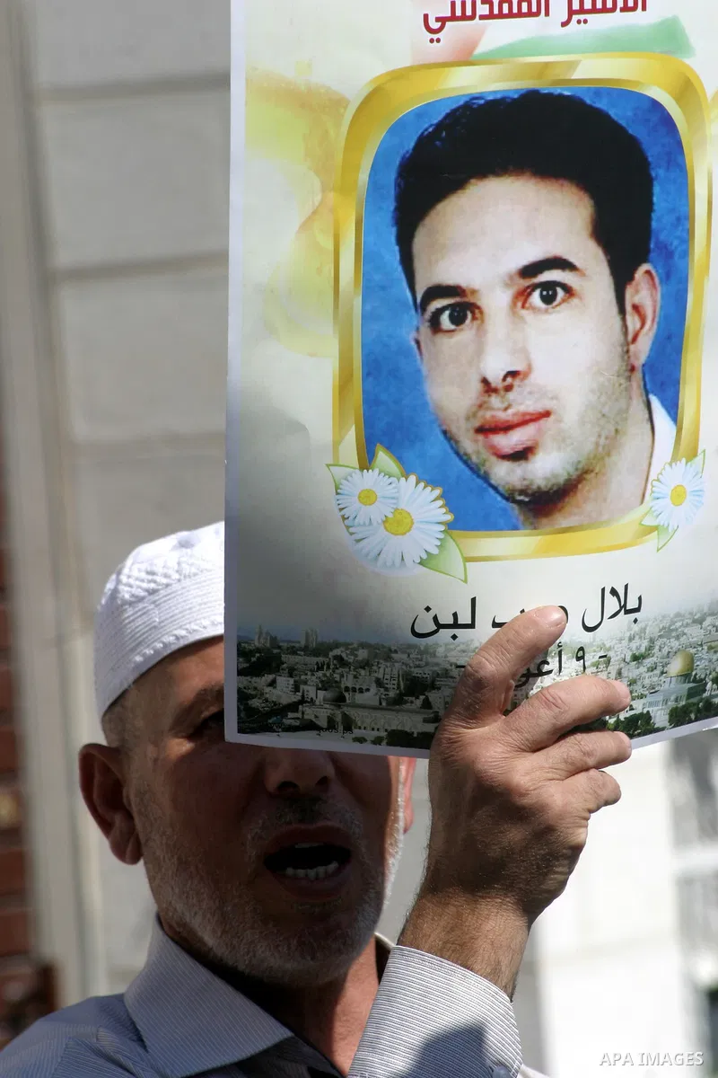 Palestinian protesters hold slogans and portraits of Palestinian prisoners, held in Israeli jails, during a demonstration in east Jerusalem on May 7, 2012 in solidarity with the prisoners. At least 1,550 imprisoned Pales...