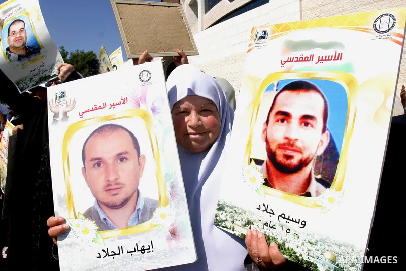 Palestinian protesters hold slogans and portraits of Palestinian prisoners, held in Israeli jails, during a demonstration in east Jerusalem on May 7, 2012 in solidarity with the prisoners. At least 1,550 imprisoned Pales...