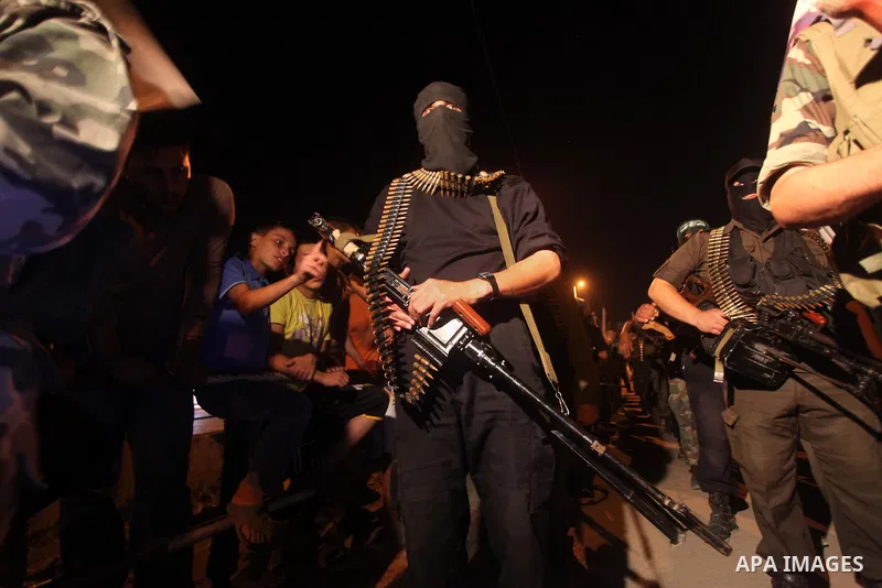Masked Hamas militants march with their guns during a parade to show solidarity with Palestinian prisoners held in Israeli jails on May 7, 2012. At least 1,550 Palestinian prisoners are refusing food in Israeli jails in...