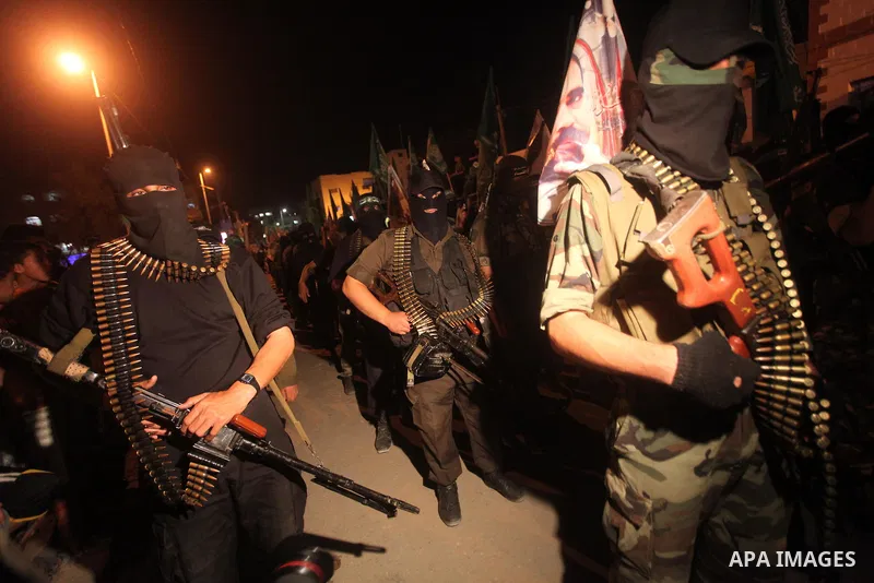Masked Hamas militants march with their guns during a parade to show solidarity with Palestinian prisoners held in Israeli jails on May 7, 2012. At least 1,550 Palestinian prisoners are refusing food in Israeli jails in...