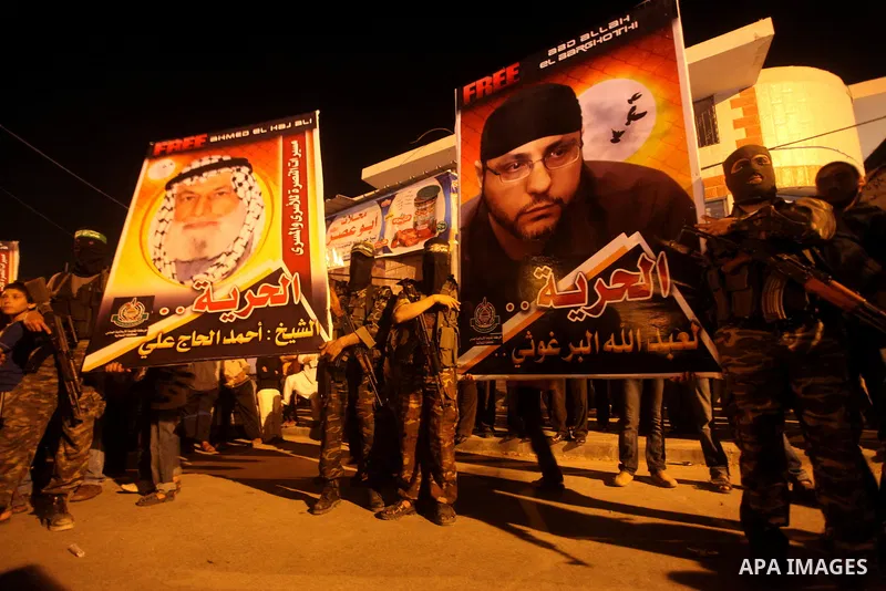 Masked Hamas militants march with their guns during a parade to show solidarity with Palestinian prisoners held in Israeli jails on May 7, 2012. At least 1,550 Palestinian prisoners are refusing food in Israeli jails in...