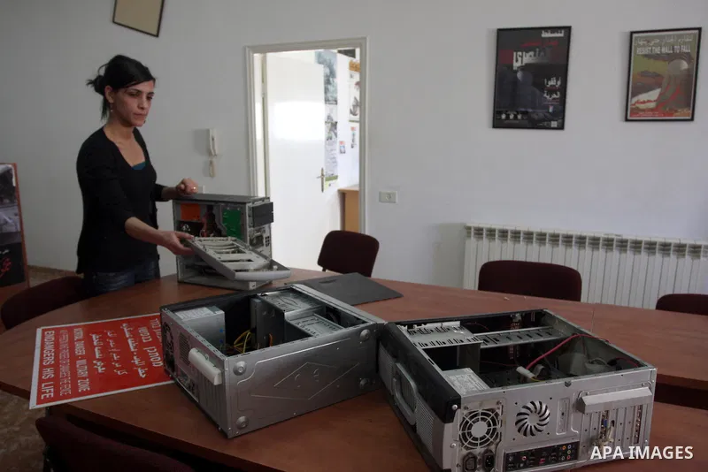 A Palestinian activist shows dismantled computers on May 8, 2012 at the offices of the Stop the Wall Campaign, a grassroots' movement overseeing the stuggle of the popoular committess in the West Bank against the controv...