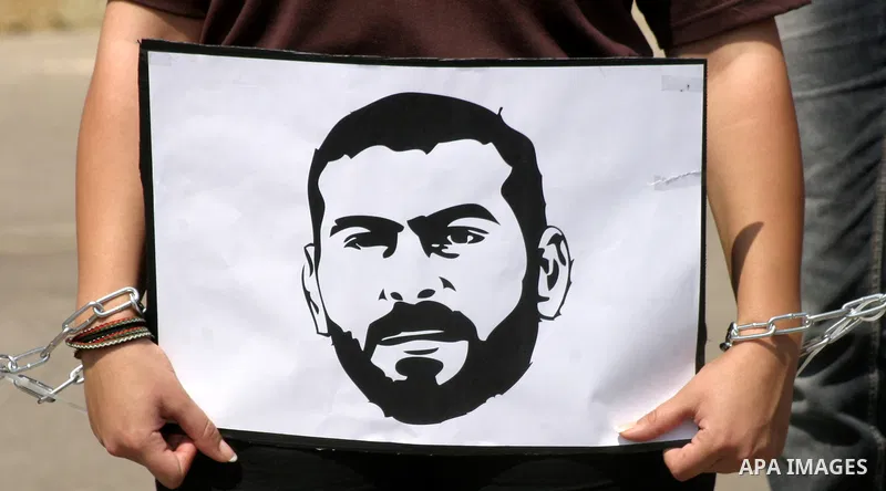 Palestinian protesters hold slogans and portraits of Palestinian prisoners, held in Israeli jails, during a demonstration in east Jerusalem on May 8, 2012 in solidarity with the prisoners. At least 1,550 imprisoned Pales...