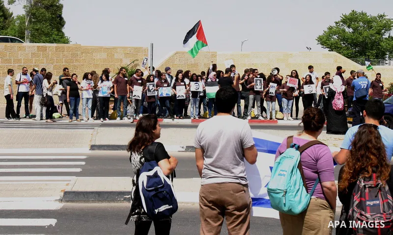 Palestinian protesters hold slogans and portraits of Palestinian prisoners, held in Israeli jails, during a demonstration in east Jerusalem on May 8, 2012 in solidarity with the prisoners. At least 1,550 imprisoned Pales...