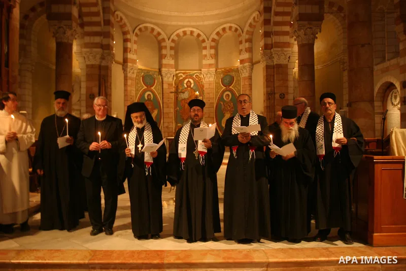 Palestinian Christians and Muslims hold pictures of incarcerated relatives during a special service at the Dominican monastery of Saint-Etienne in east Jerusalem on May 8, 2012 in solidarity with prisoners on hunger stri...