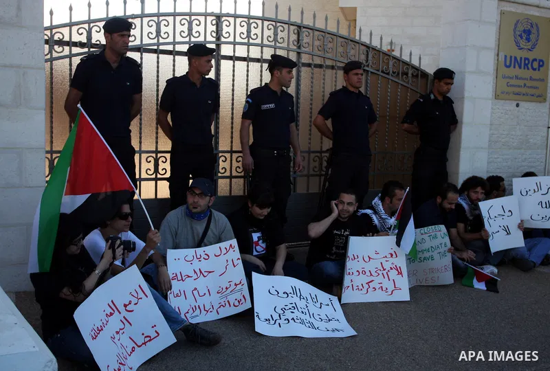 Palestinian security forces monitor a protest by dozens of activists who blocked the main gate of the UN offices in the West Bank city of Ramallah on May 9, 2012 to prevent the international organisation's staff from ent...