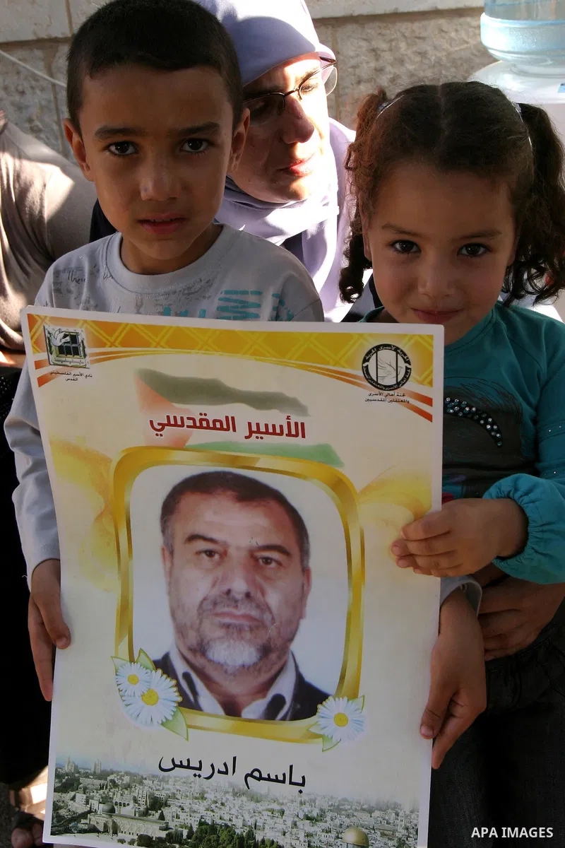 Palestinian children hold up portraits of Palestinian prisoners, held in Israeli jails, during a demonstration in front of the Red Cross center, east Jerusalem, on May 9, 2012 in solidarity with the prisoners. At least 1...