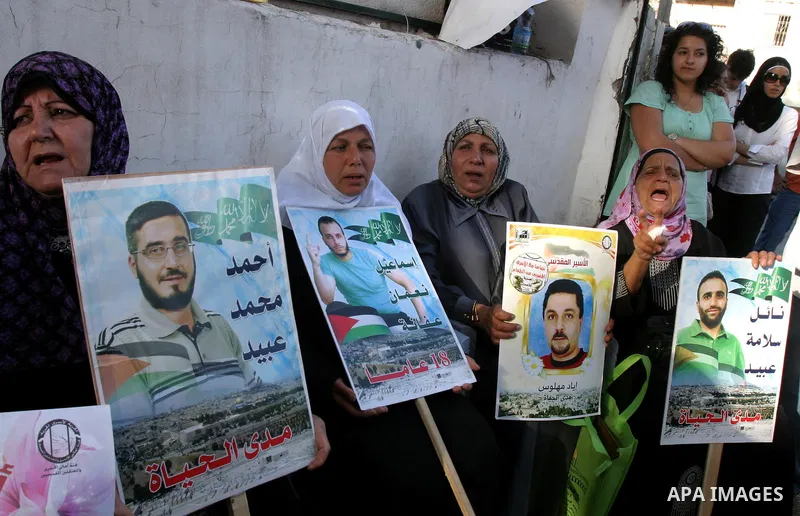 Palestinian protesters hold up portraits of Palestinian prisoners, held in Israeli jails, during a demonstration in front of the Red Cross center, east Jerusalem, on May 9, 2012 in solidarity with the prisoners. At least...