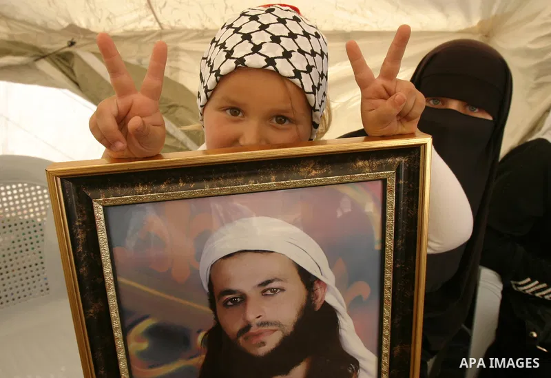 Palestinian child holds up portrait of Palestinian prisoner, held in Israeli jails, during a demonstration in front of the Red Cross center, east Jerusalem, on May 9, 2012 in solidarity with the prisoners. At least 1,550...