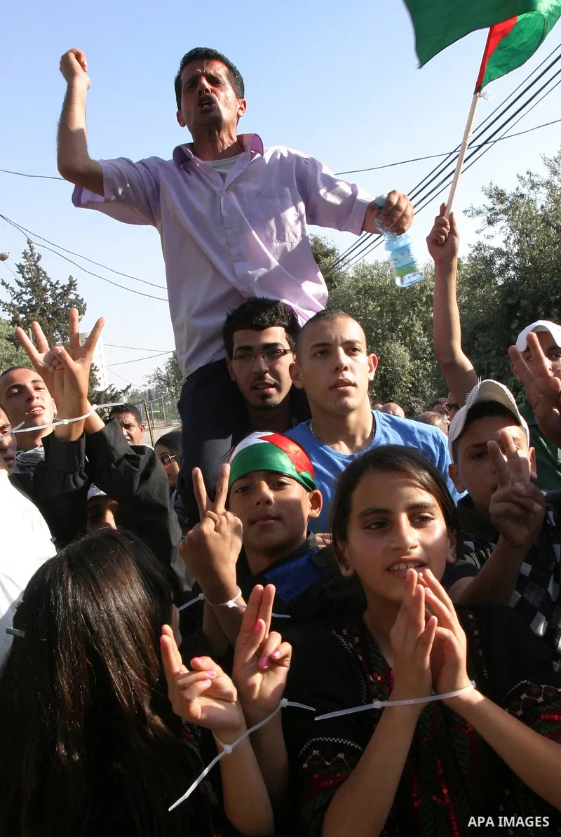 Palestinian children hold up portraits of Palestinian prisoners, held in Israeli jails, during a demonstration in front of the Red Cross center, east Jerusalem, on May 9, 2012 in solidarity with the prisoners. At least 1...