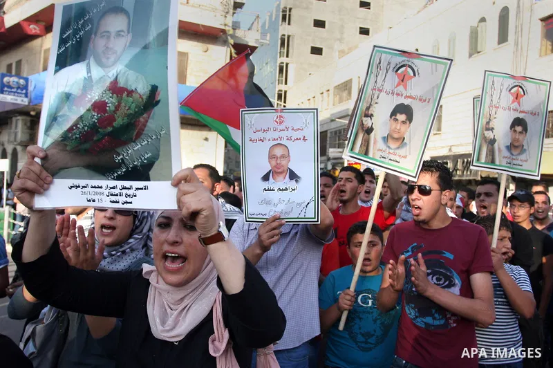 Palestinians participate in a rally supporting Palestinian inmates on hunger strike since mid-April 2012, in the West Bank City of Ramallah, May 9, 2012. A Palestinian rights group said recently that half of about 5,000...