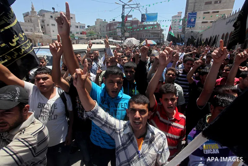 Palestinians hold up portraits of Palestinian prisoners, held in Israeli jails, and shout slogans during a demonstration in southern Gaza strip, city of Khan Younis, on May 11, 2012 in solidarity with the prisoners. At l...