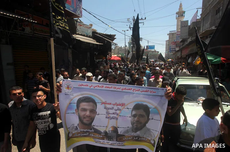 Palestinians hold up portraits of Palestinian prisoners, held in Israeli jails, and shout slogans during a demonstration in southern Gaza strip, city of Khan Younis, on May 11, 2012 in solidarity with the prisoners. At l...