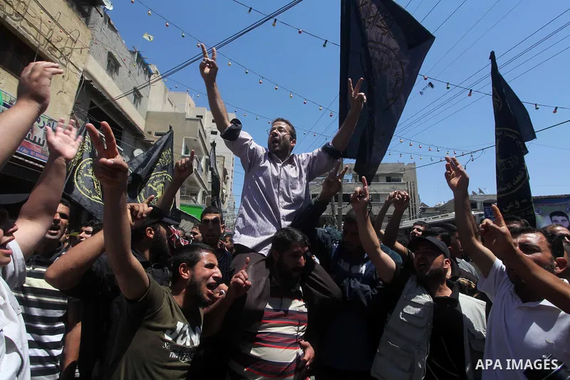 Palestinians hold up portraits of Palestinian prisoners, held in Israeli jails, and shout slogans during a demonstration in southern Gaza strip, city of Khan Younis, on May 11, 2012 in solidarity with the prisoners. At l...