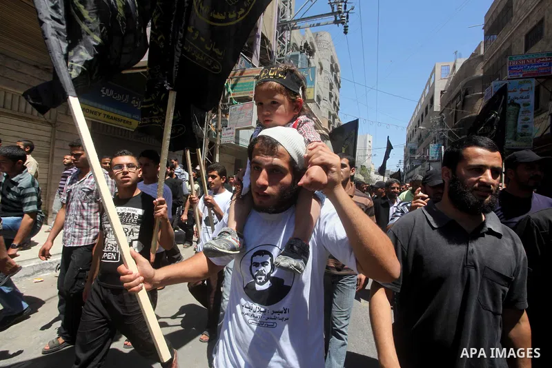 Palestinians hold up portraits of Palestinian prisoners, held in Israeli jails, and shout slogans during a demonstration in southern Gaza strip, city of Khan Younis, on May 11, 2012 in solidarity with the prisoners. At l...