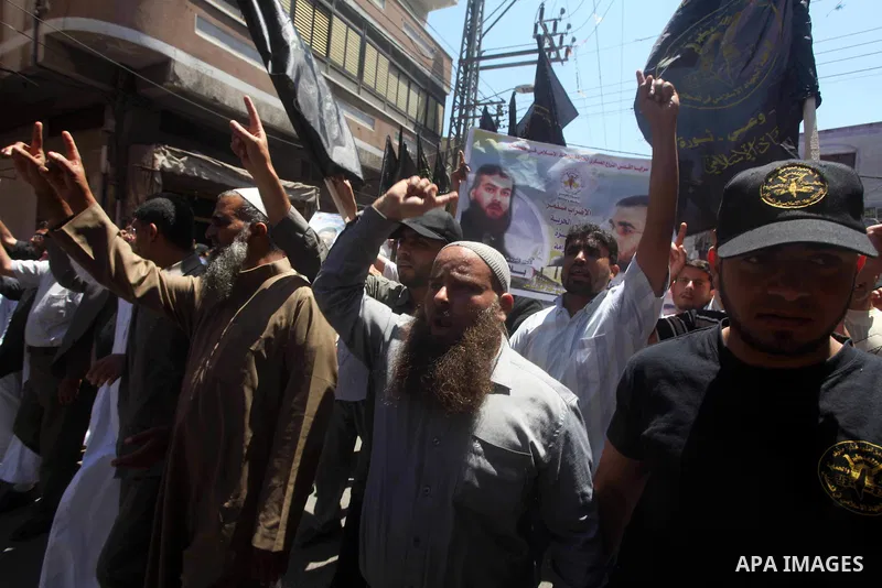 Palestinians hold up portraits of Palestinian prisoners, held in Israeli jails, and shout slogans during a demonstration in southern Gaza strip, city of Khan Younis, on May 11, 2012 in solidarity with the prisoners. At l...