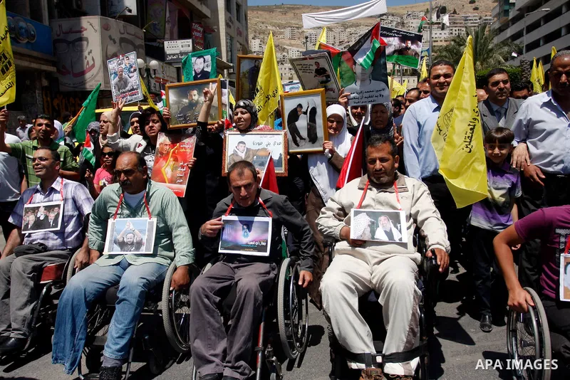 Palestinians participate a demonstration, and hold portraits of prisoners held in Israeli jails, following perform Friday prayers during a sit-in, in the West Bank city of Nablus, May 11, 2012. Palestinians held in praye...