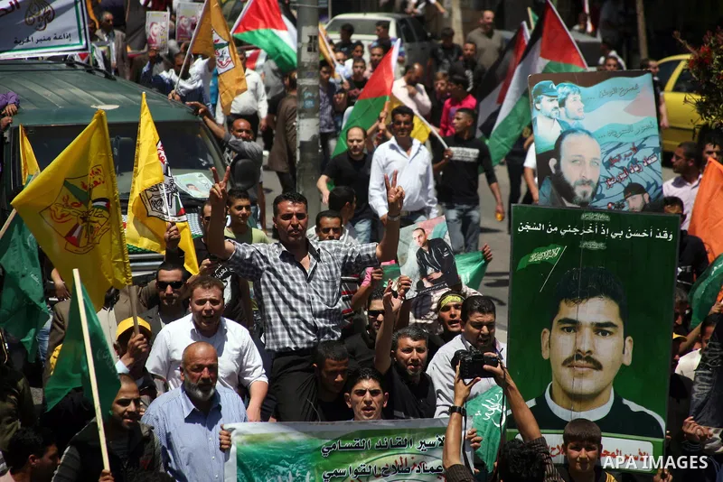 Palestinians participate a demonstration, and hold portraits of prisoners held in Israeli jails, solidarity with prisoners who have been waging a hunger strike in Israeli jails, on May 11, 2012, in the West Bank city of...
